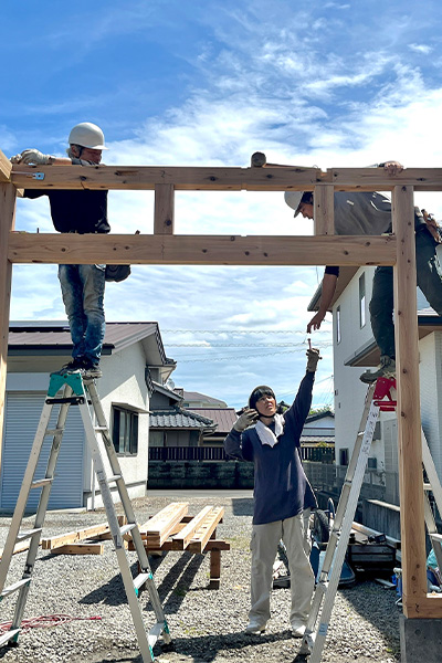 家族で協力しながら農作業小屋を建てている様子